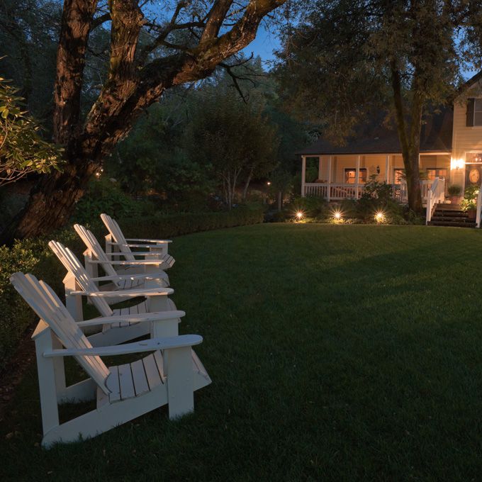 有四个白色草坪椅子的围场在黄昏