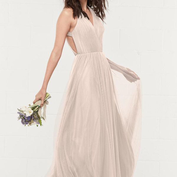 女性在flowy米色礼服控股花束