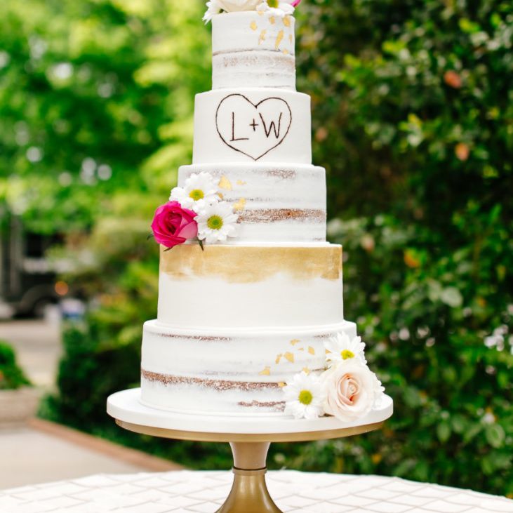 高婚礼蛋糕裸露层和明亮的粉红色花