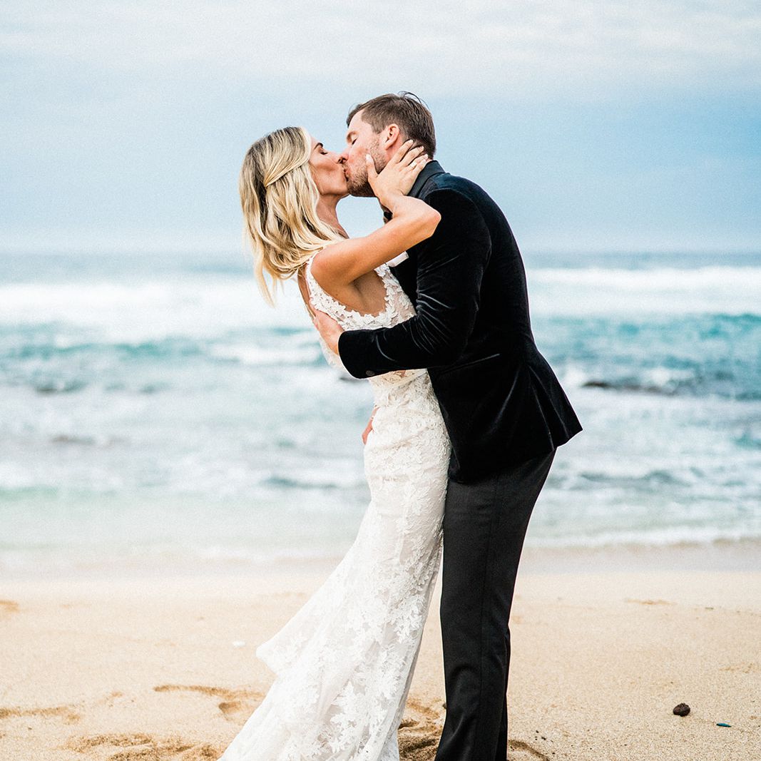 新娘和新郎在海滩上接吻