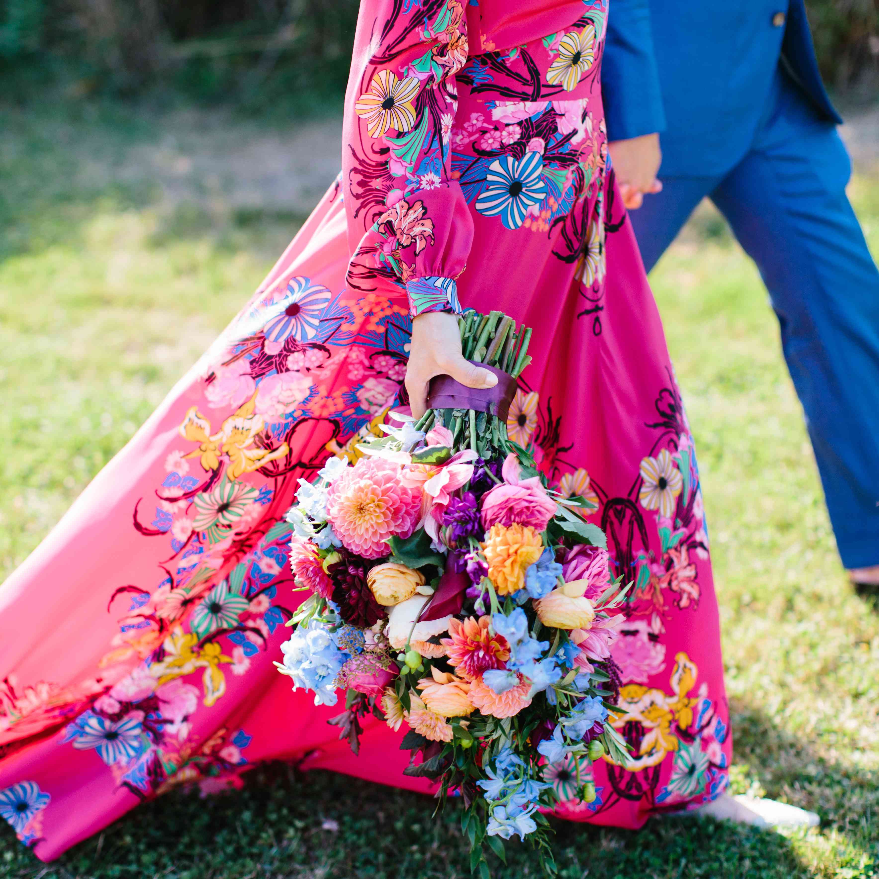 穿五颜六色的礼服的妇女拿着花