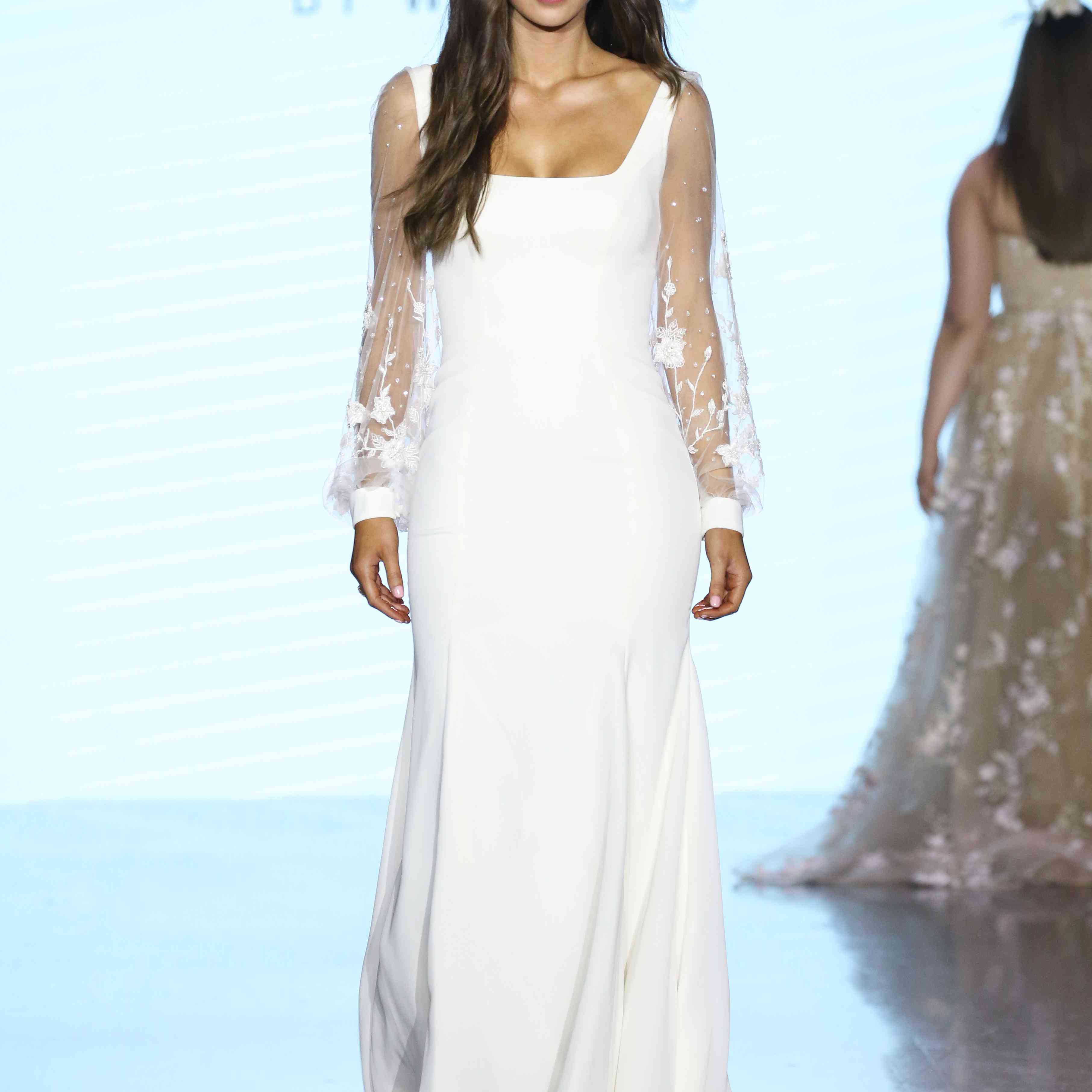 模特穿着方形领口和花卉刺绣的梦幻长袖绉纱婚纱