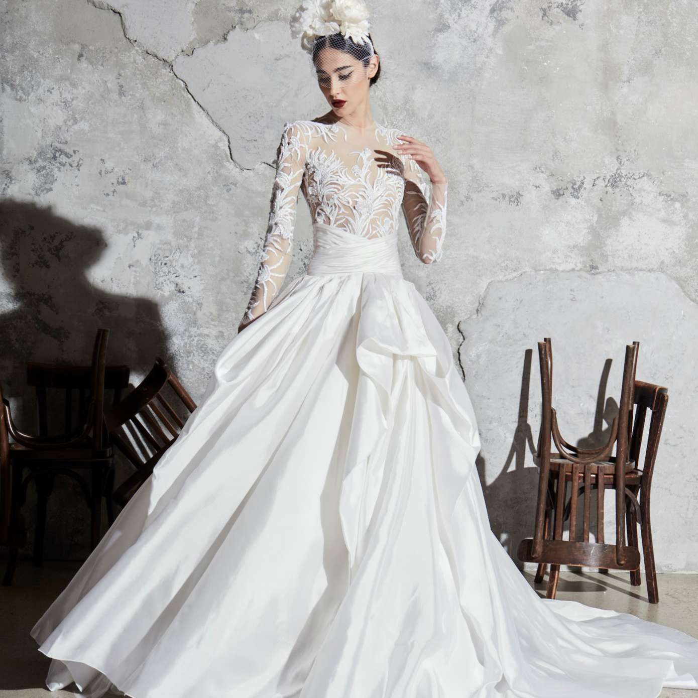 模特穿着一件长袖刺绣的梦幻紧身礼服，一条下垂的腰带，和一条聚集的丝绸裙子