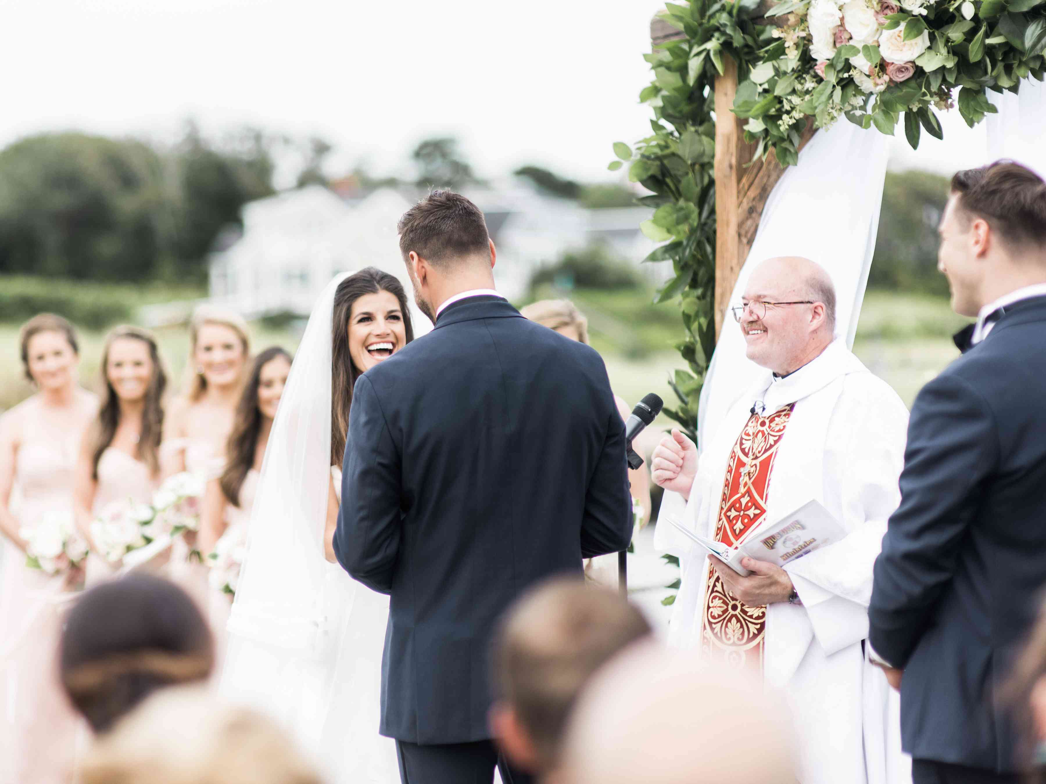 新郎新娘站在祭坛前，祭坛上覆盖着绿色植物和鲜花