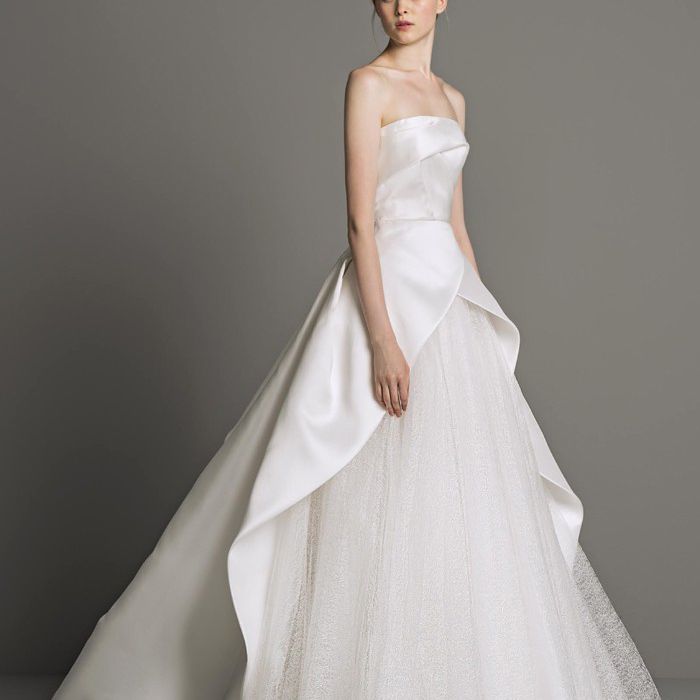 模特身着无肩带礼服，裙摆悬垂，薄纱衬裙