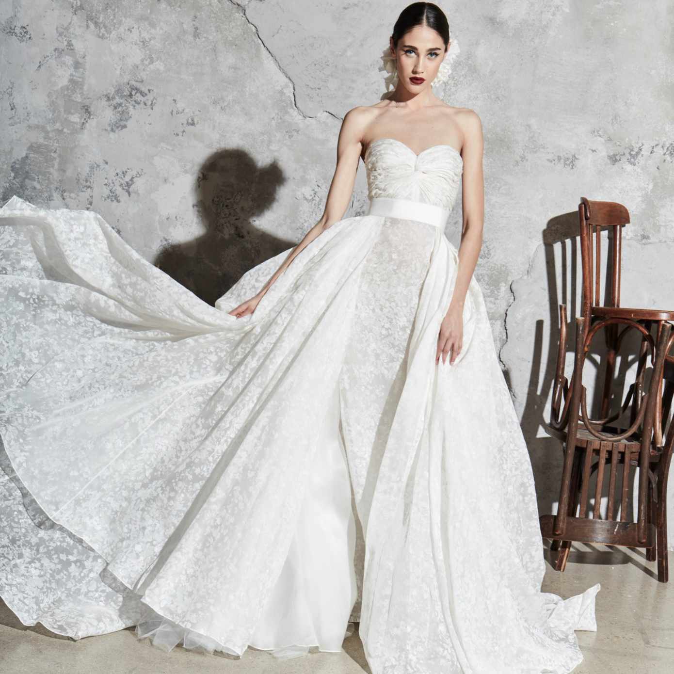 模特身穿无肩带的碎花舞会礼服，搭配宽松的罩衫和白色腰带