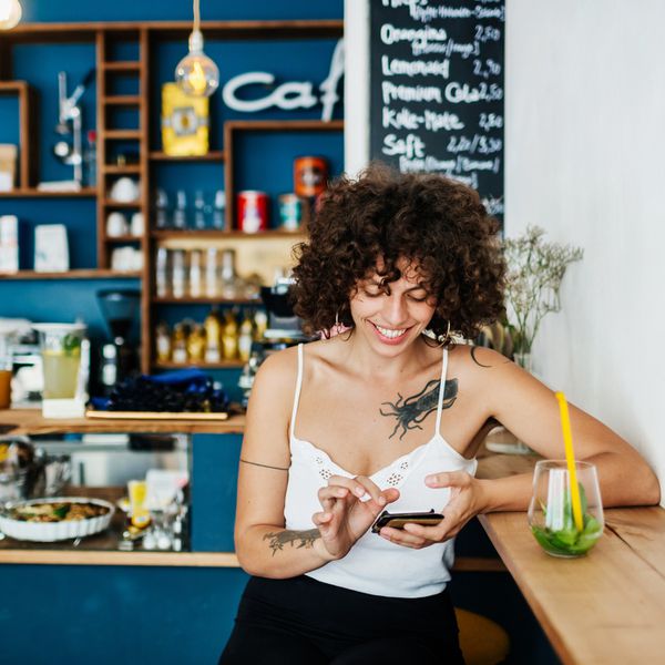 一个站在咖啡馆里刷手机的女人