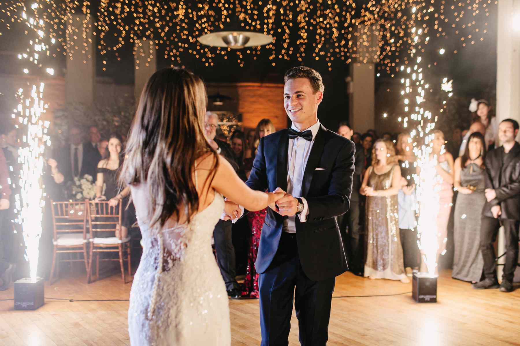 新娘和新郎在悬挂的彩灯下跳舞