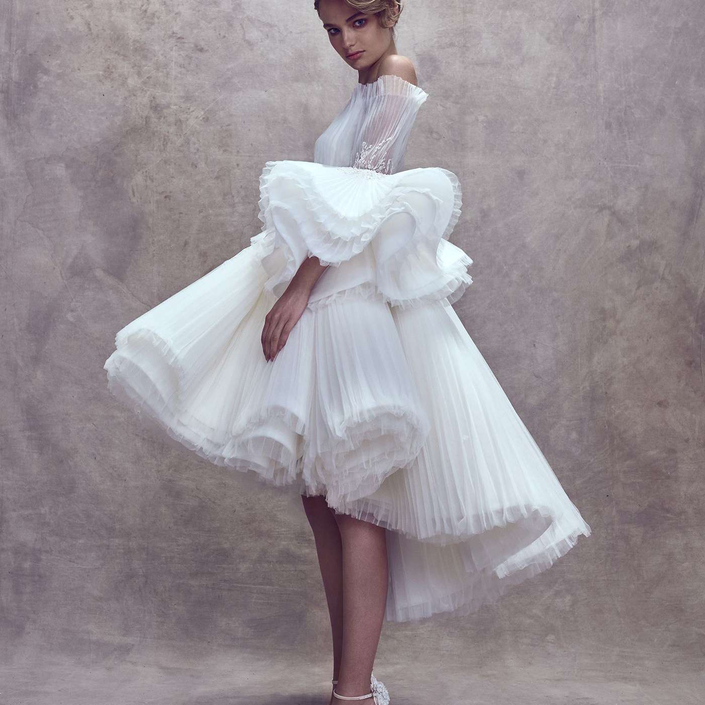 模特身穿露肩裙，搭配高低层薄纱裙和大袖