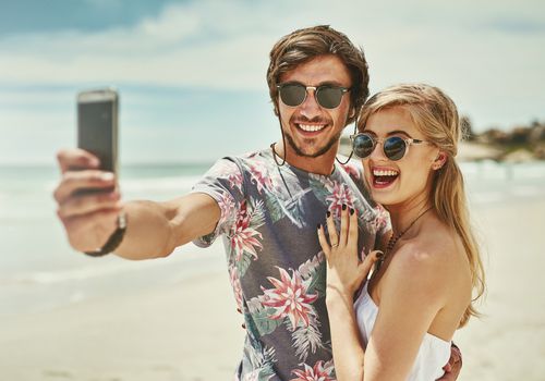 订婚的情侣在海滩上自拍