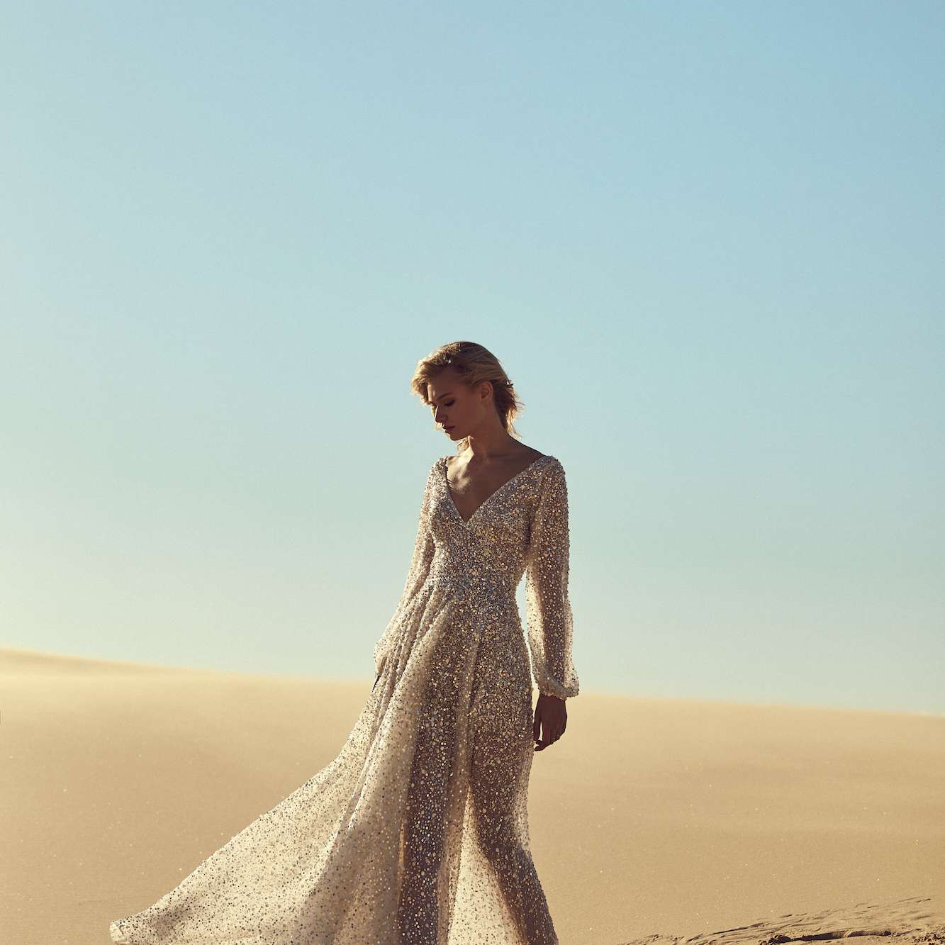 在银模型在沙漠中闪闪发光的礼服