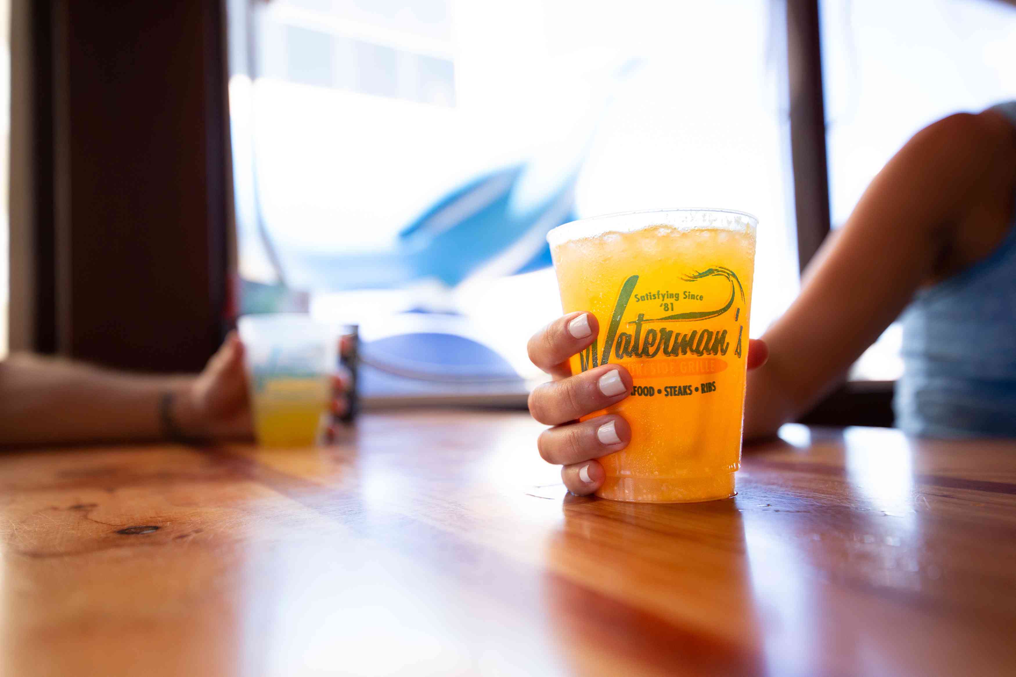 Waterman's Surfside Grille餐厅的一位女士拿着一杯橙汁鸡尾酒