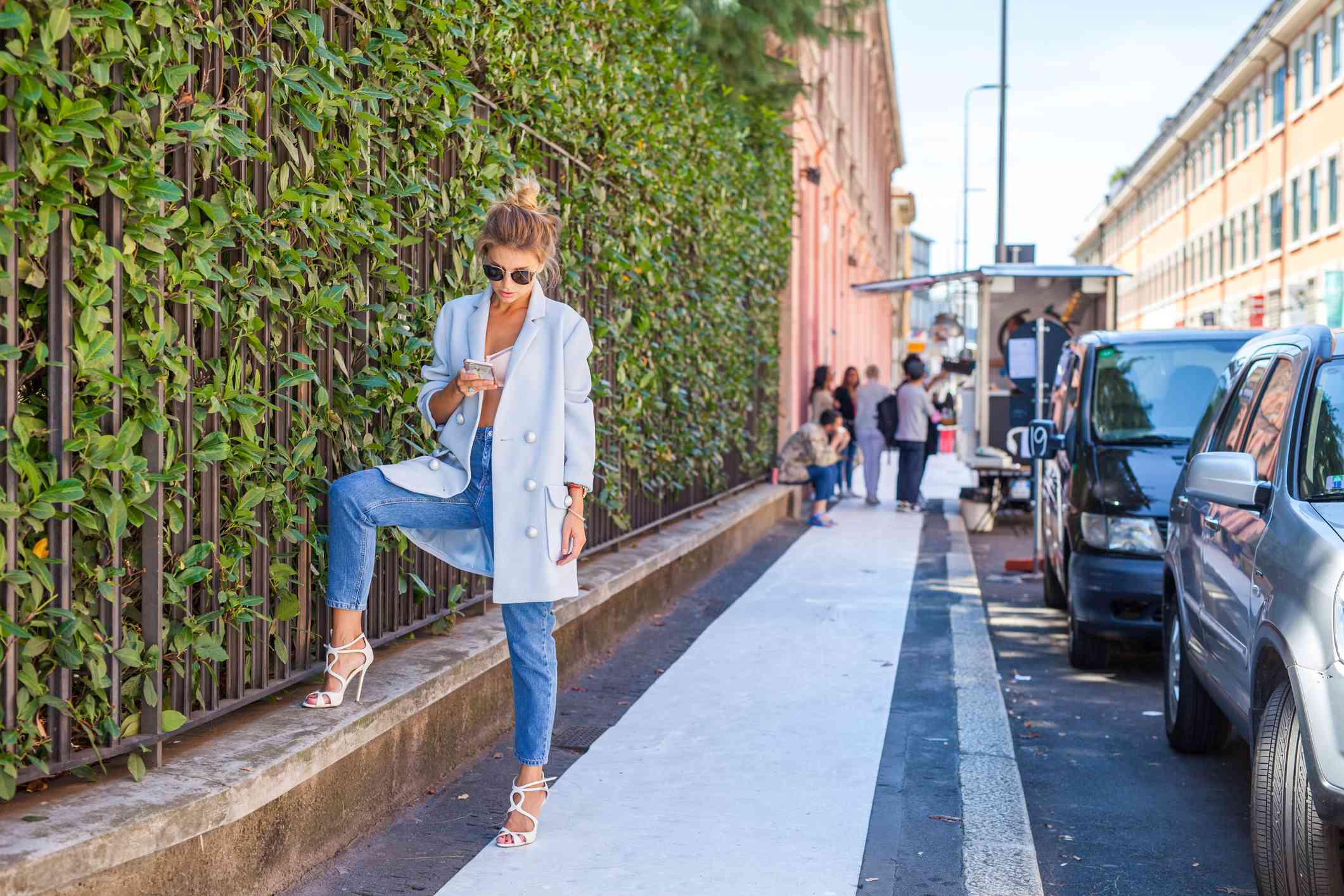 发短信在城市的时兴的妇女“class=