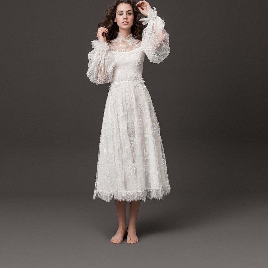 模特穿着茶色花朵刺绣长袍，蓬松袖子和流苏下摆