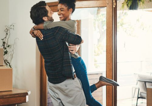 深情的中年男子抬起他的妻子在庆祝他们的新家园