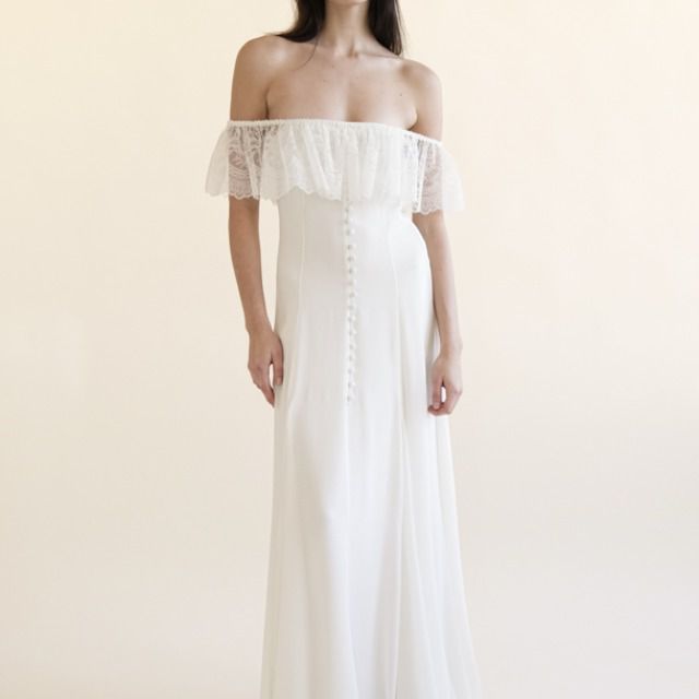 模特穿着有褶边和纽扣的露肩礼服