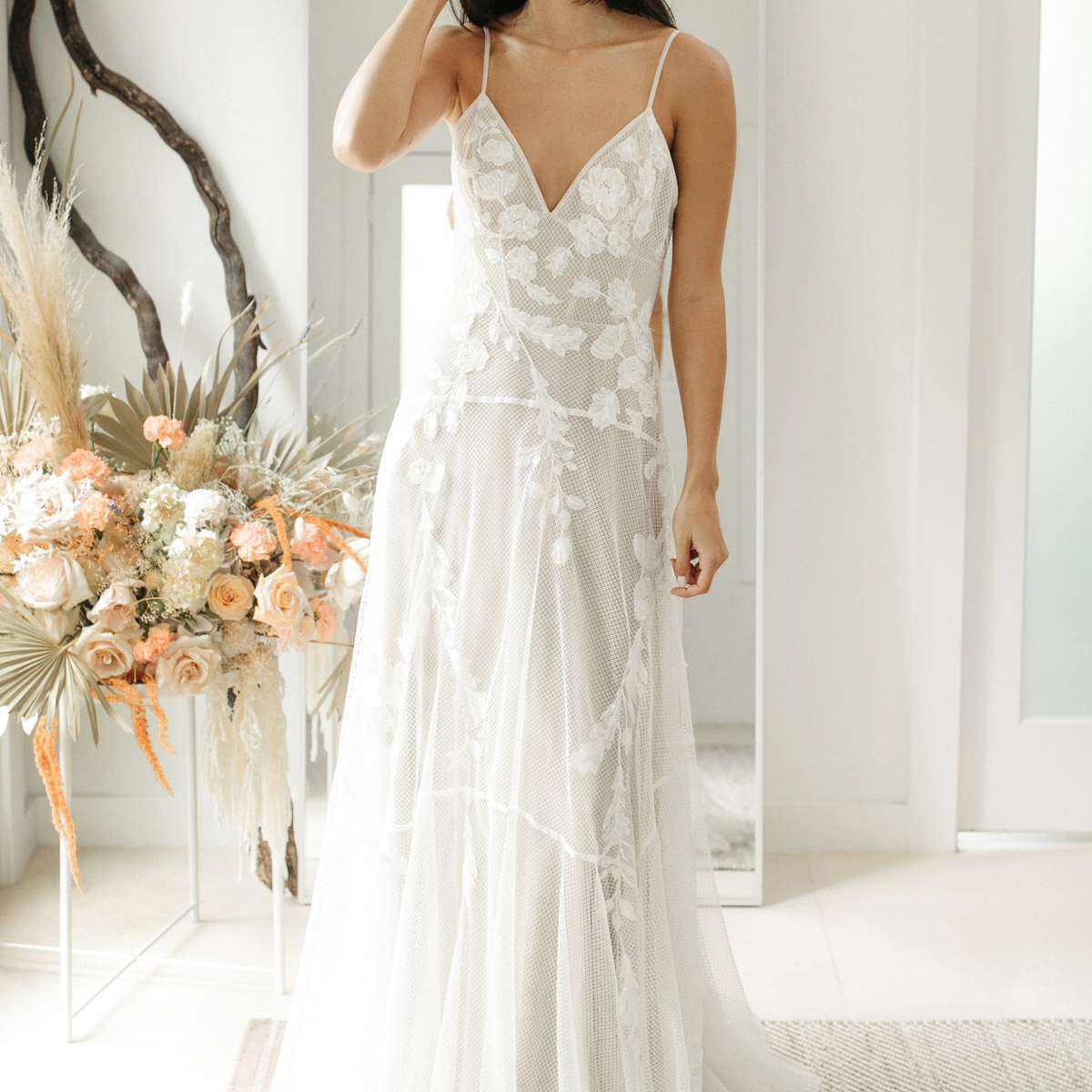 模特在带花和蝴蝶刺绣v领网礼服