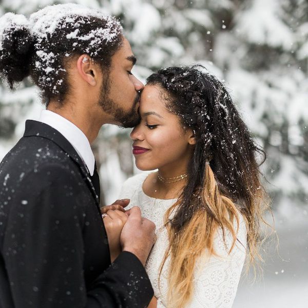 新郎在外面的雪地上亲吻新娘的额头