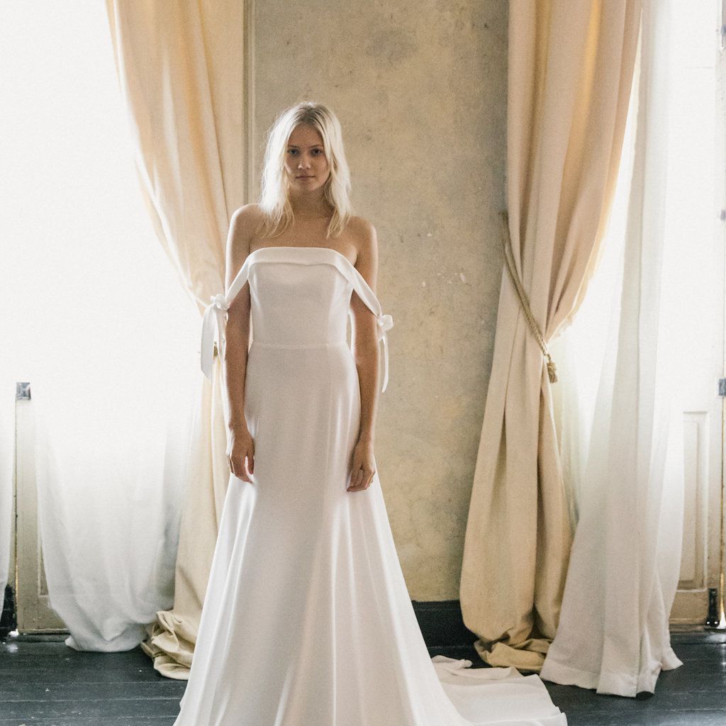 模特身穿白色礼服，系着露肩袖