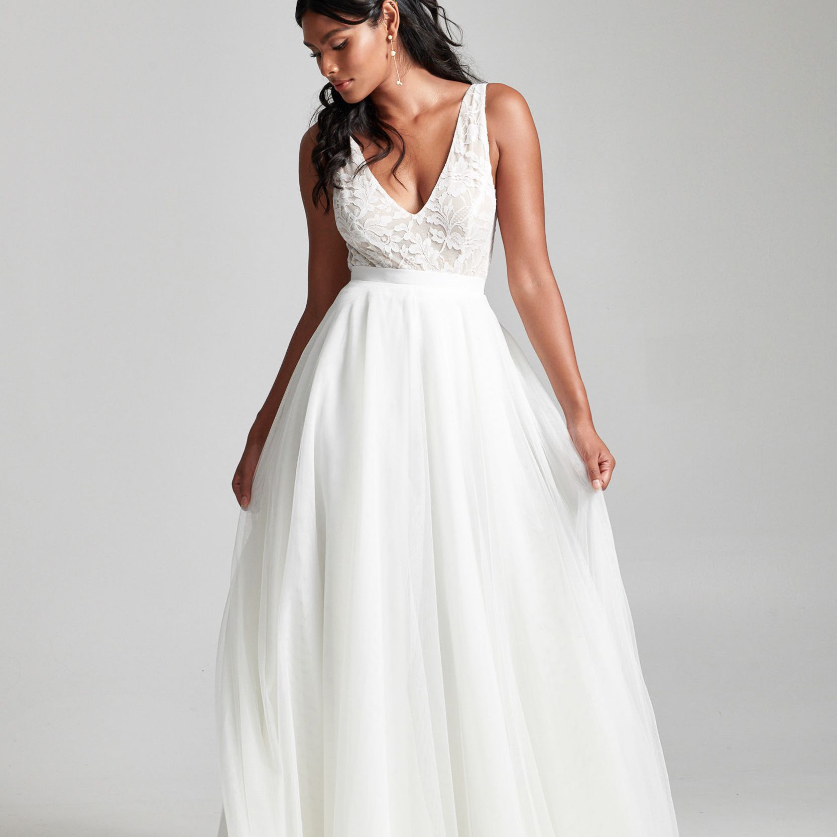 模特穿着蕾丝v领上衣和薄纱裙