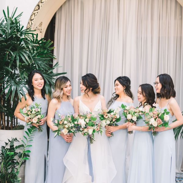 身穿淡蓝色礼服的伴娘和新娘站在一起