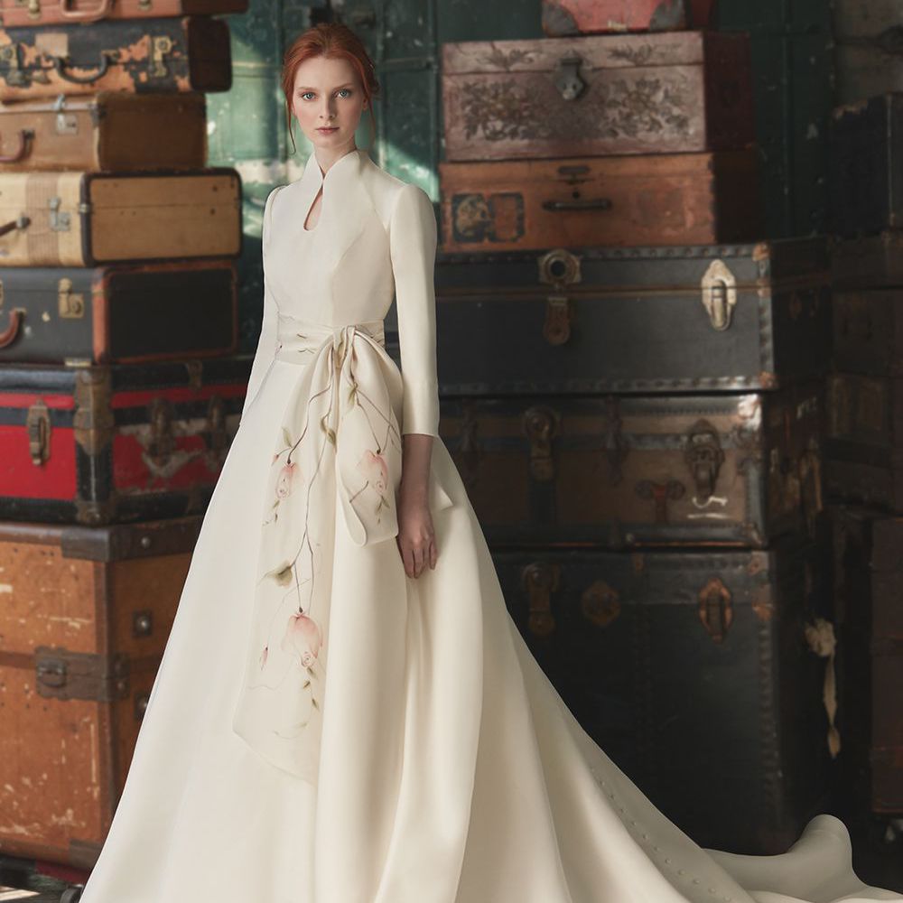 模特在绉纱婚礼礼服与全裙，四分之一长的袖子，和高领口与锁孔