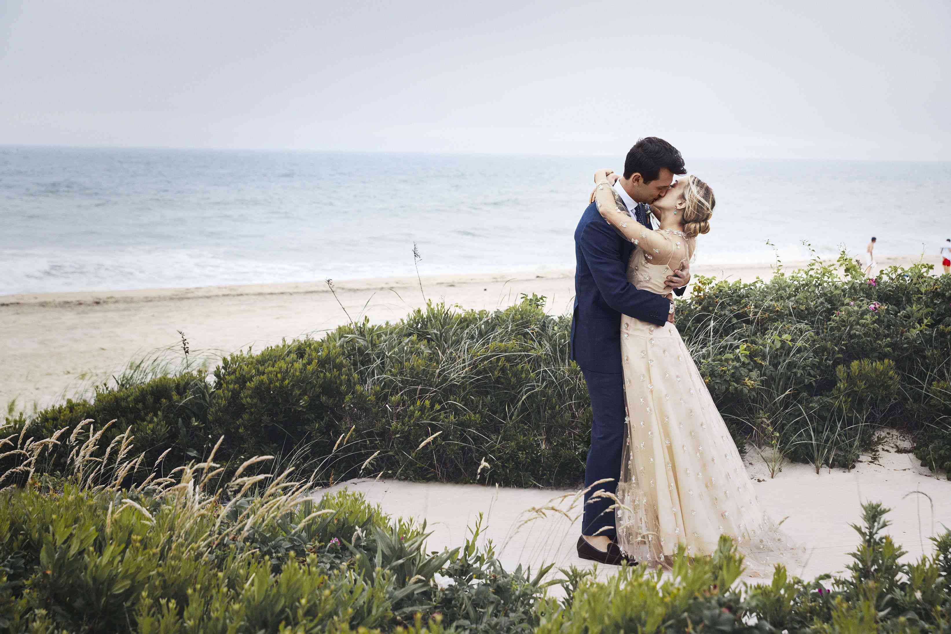 亲吻在海滩的绿叶的夫妇