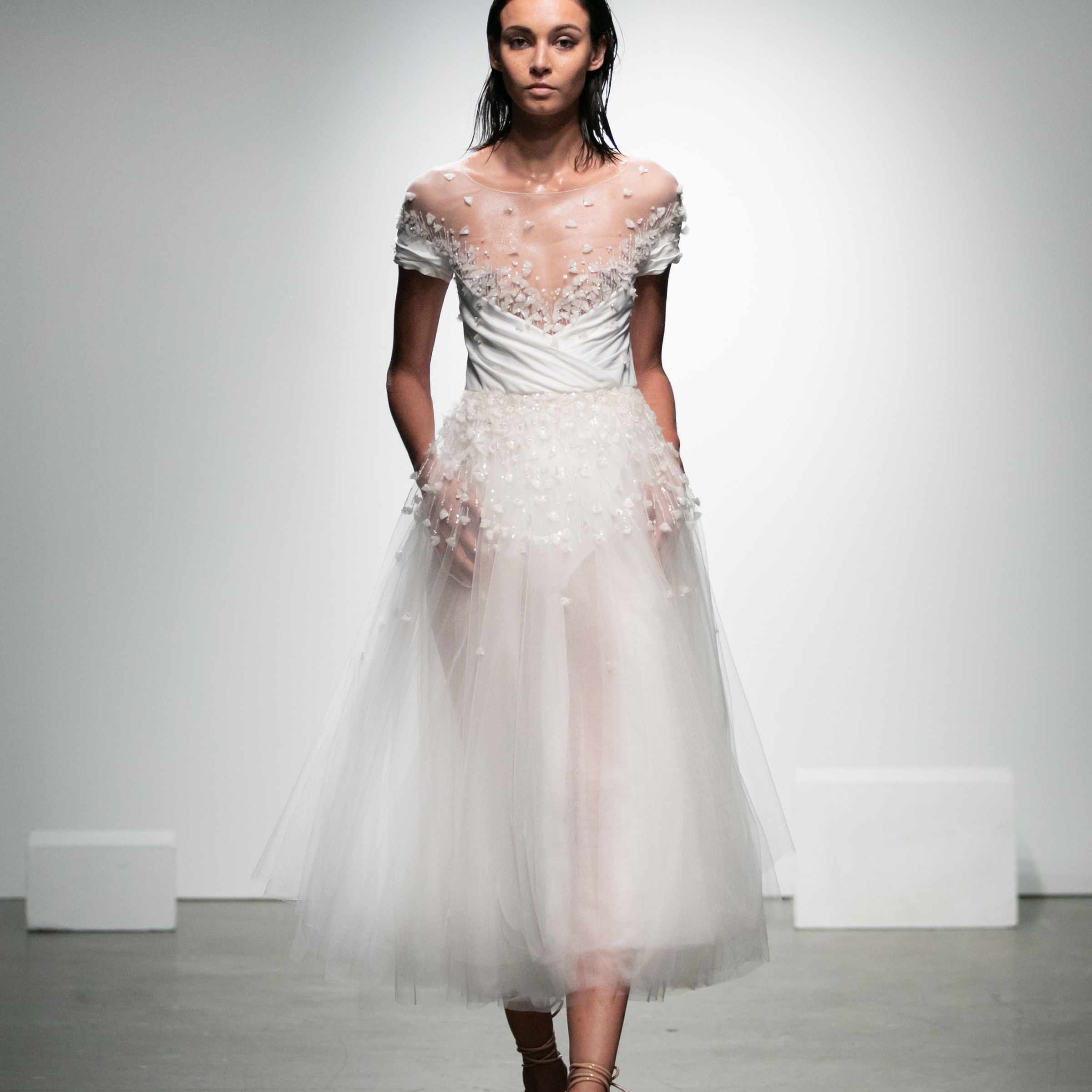 模特穿着长至茶色的薄纱连衣裙，带有花卉刺绣和短袖