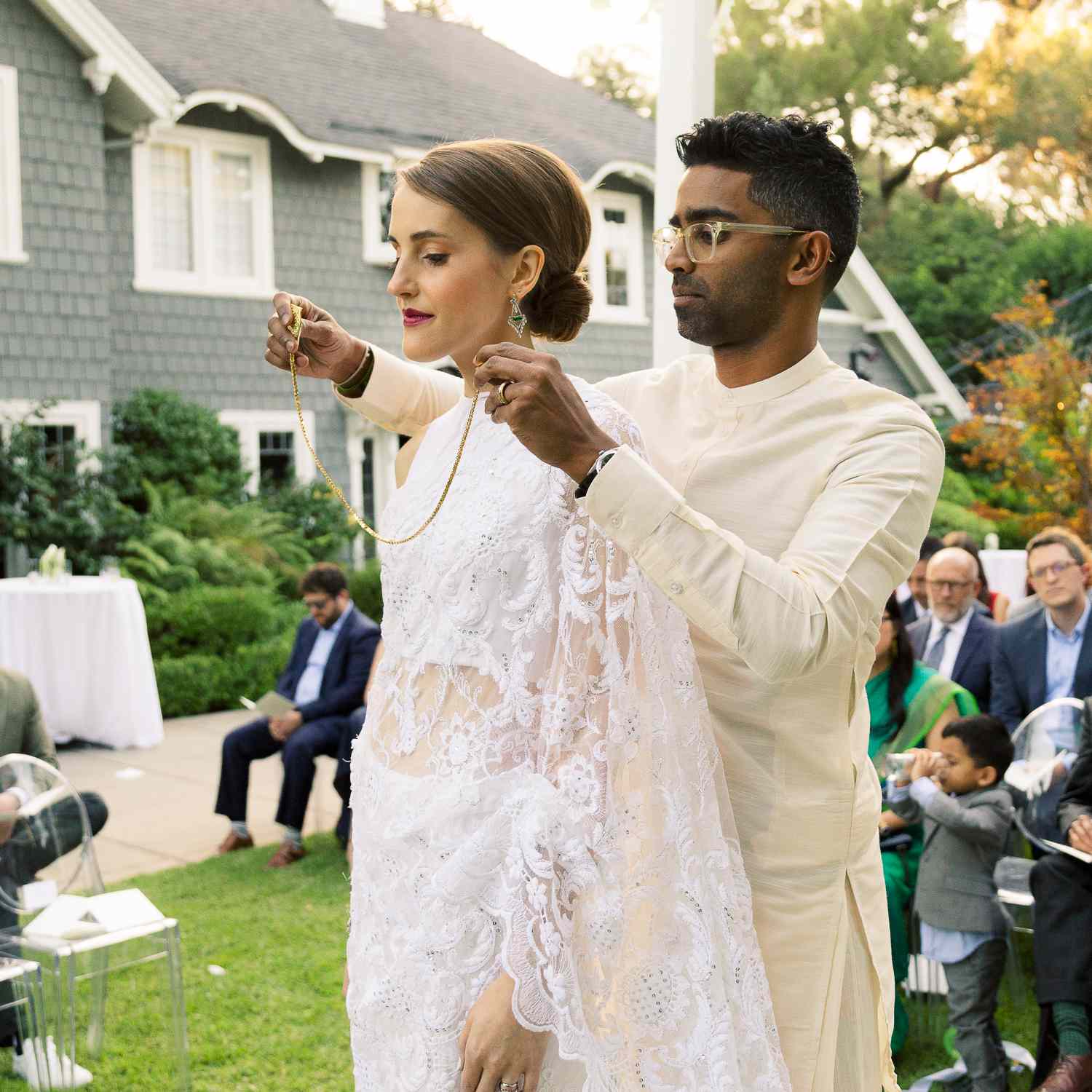 groom putting necklace on bride