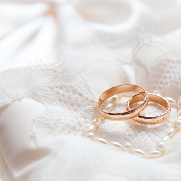 花边枕头上的两个金结婚戒指