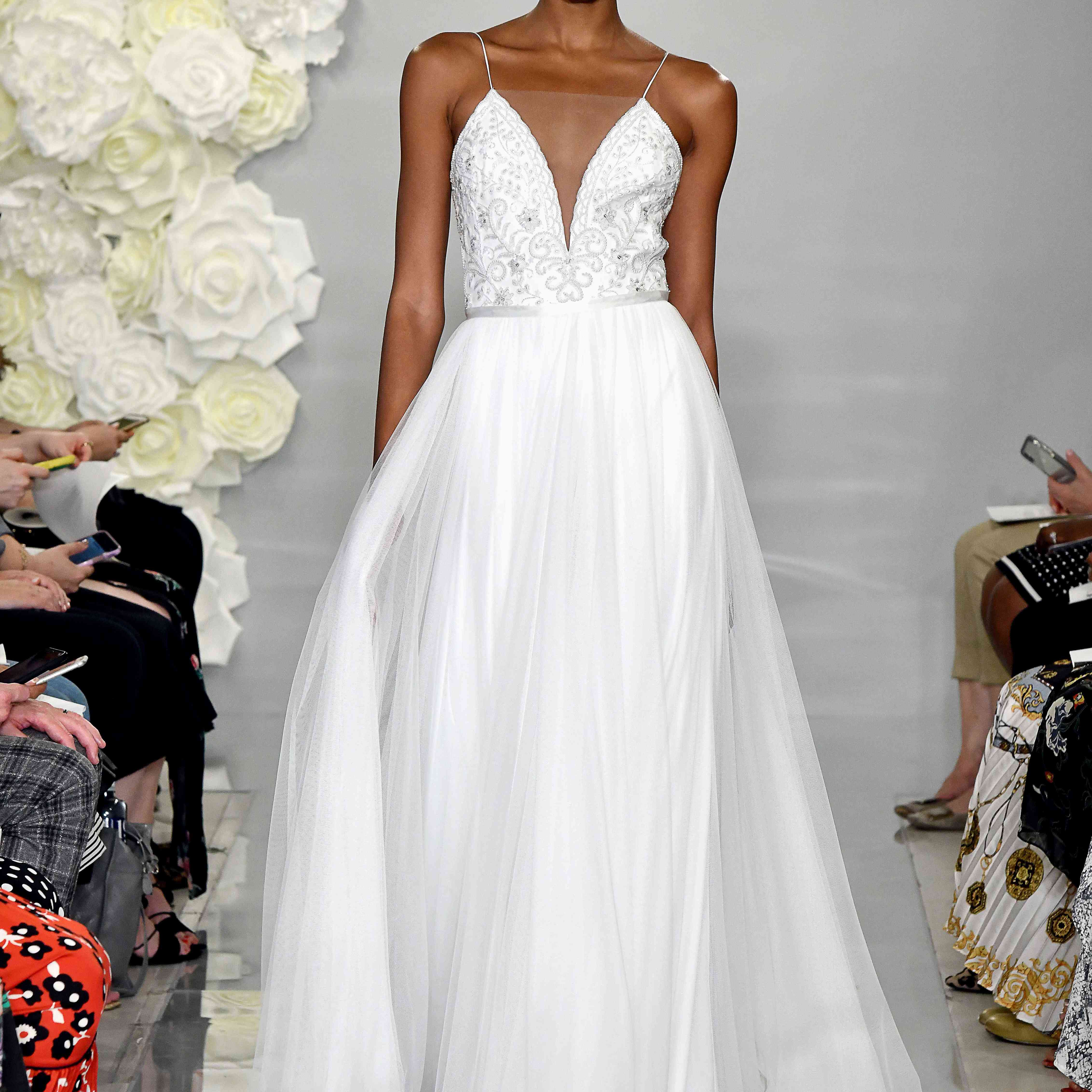 模型在跑道上舞会礼服领口串珠的紧身上衣和幻觉的薄纱裙子