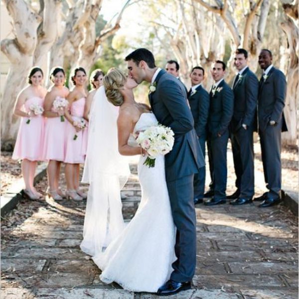 已婚夫妇亲吻，而新娘站在背景