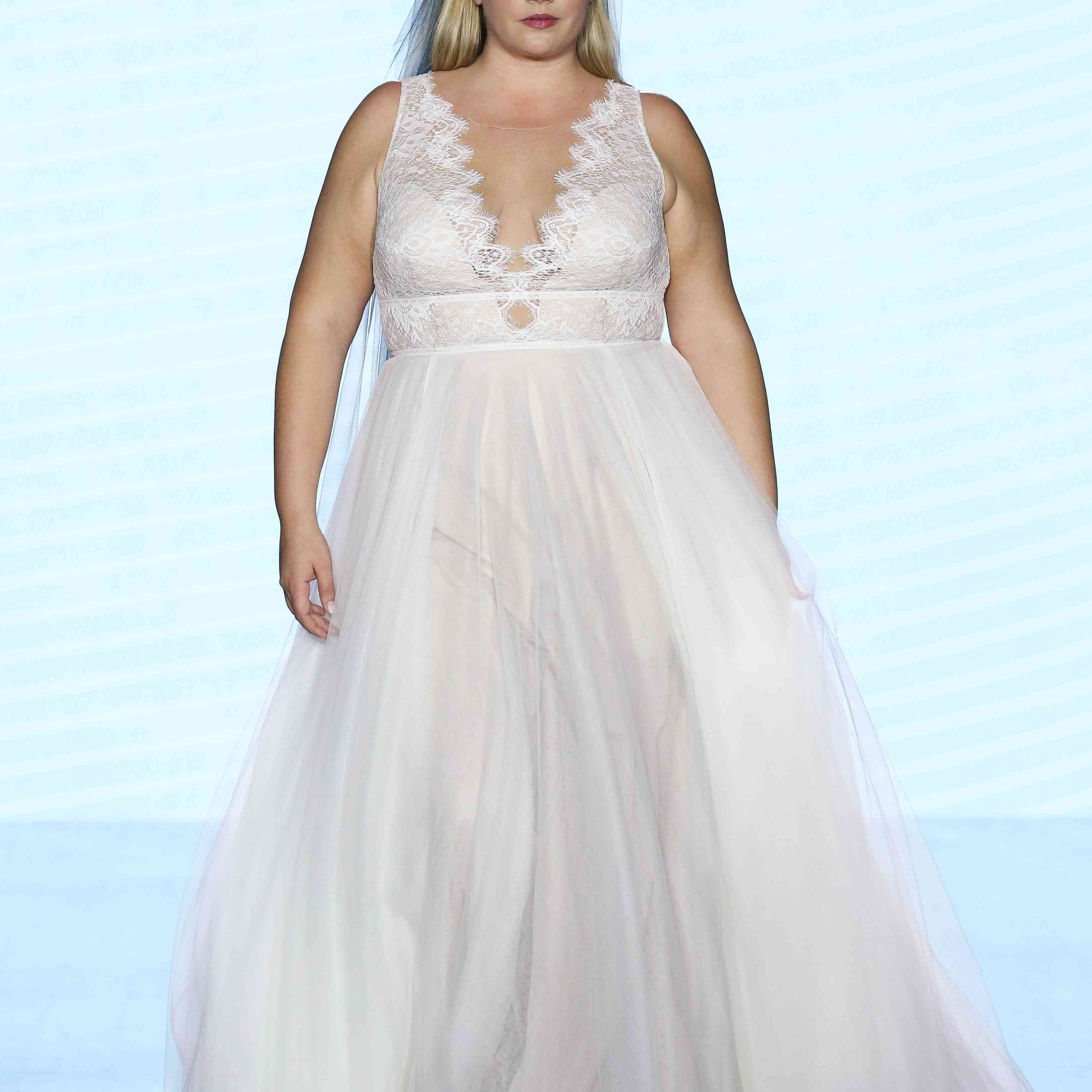 模特在舞会礼服扇形边花边胸衣与深v领口和薄纱裙子