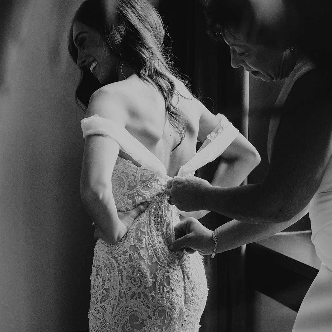 mom zipping bride's dress