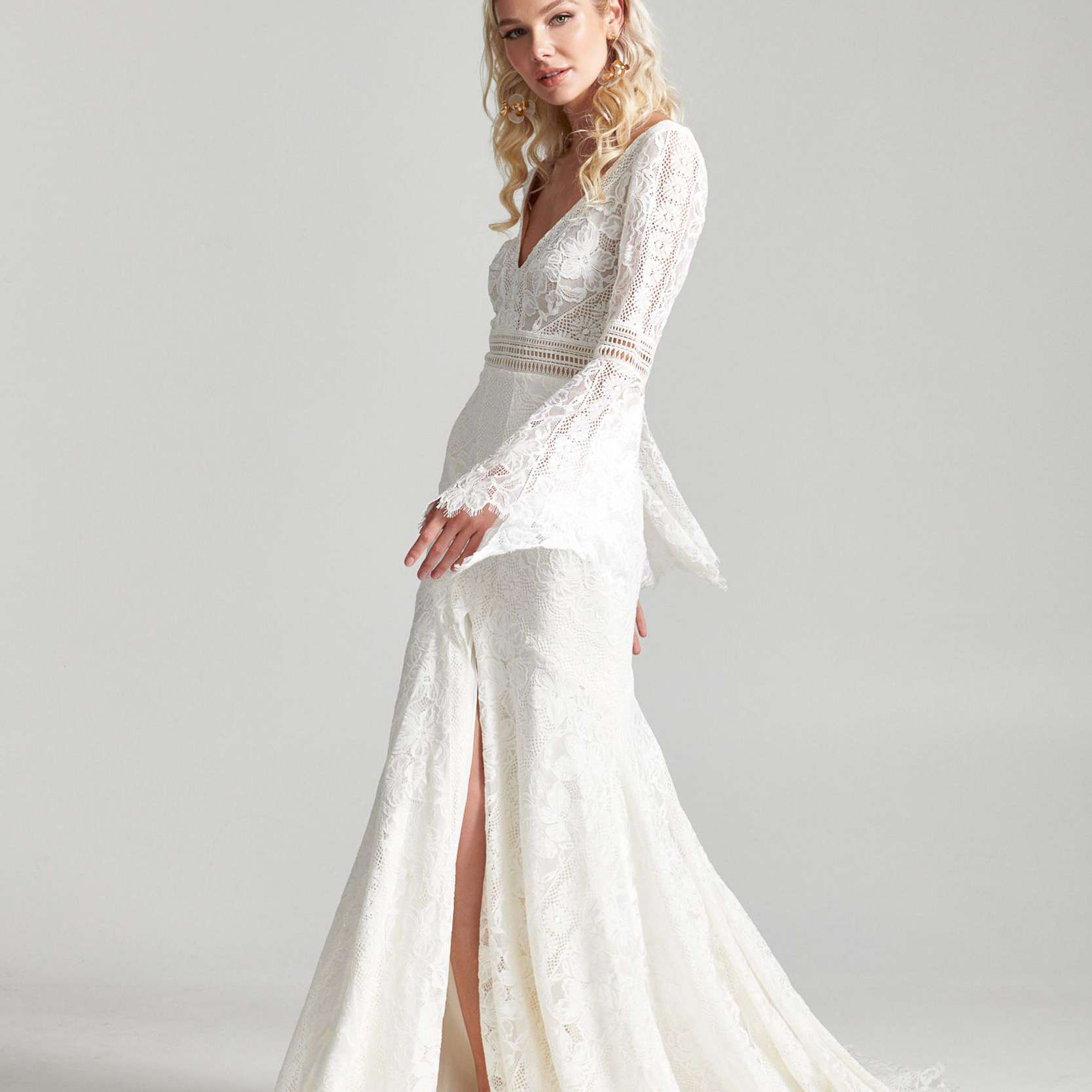 模特在花边结婚礼服与长钟袖和裙子开叉