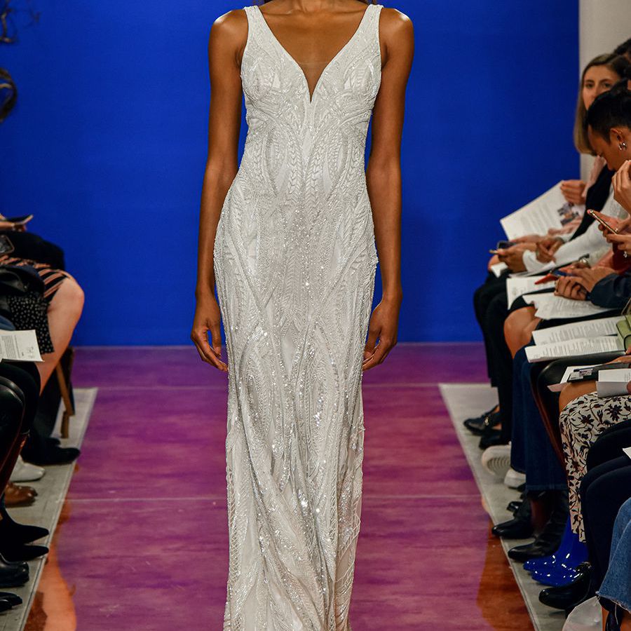 跑道模型穿着无肩带鞘礼服与v领和串珠刺绣