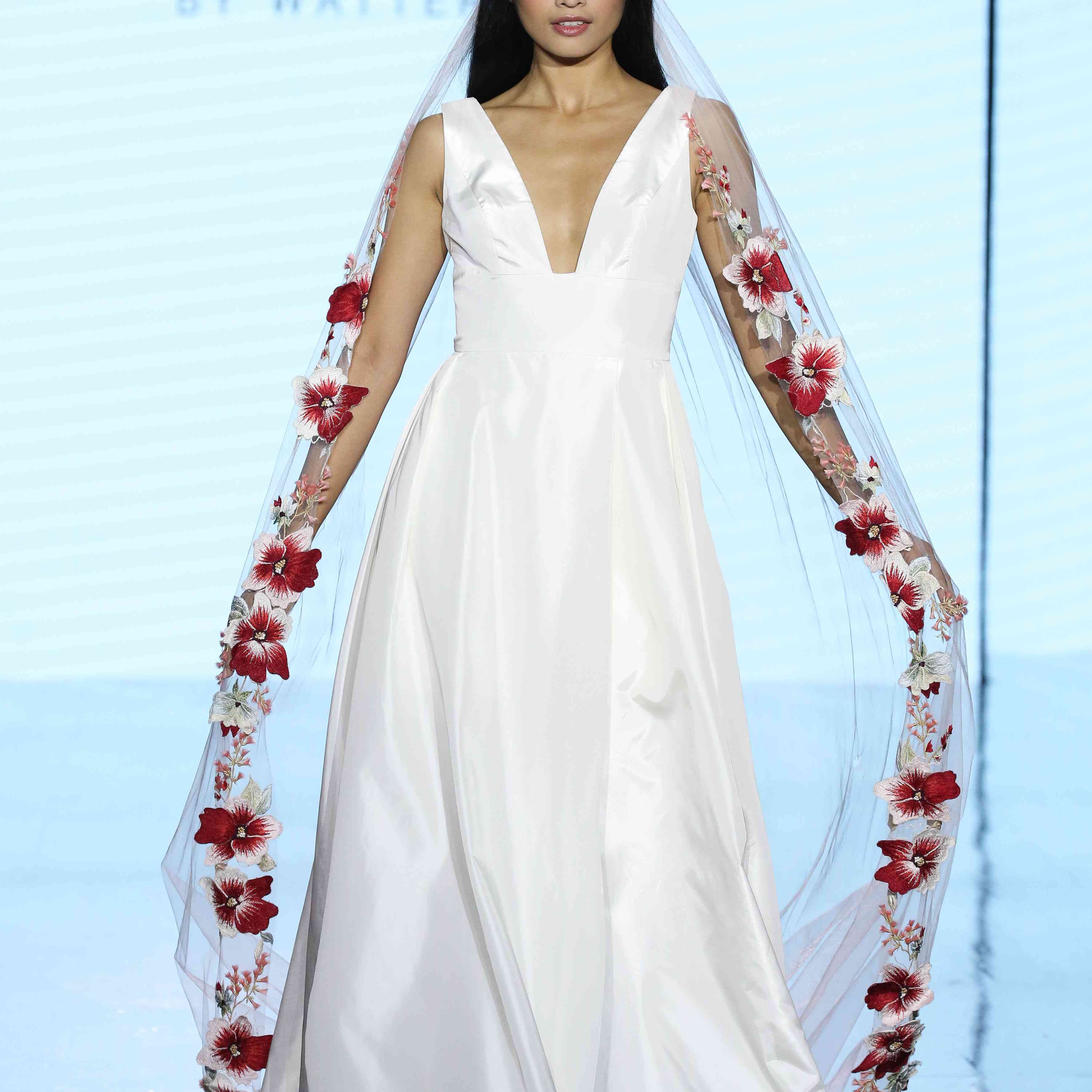 无袖缎面婚纱的模型，带有一个猛烈的领口和带状腰部