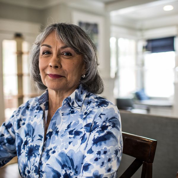 坐与内容的退休的资深妇女在她的面孔看“class=