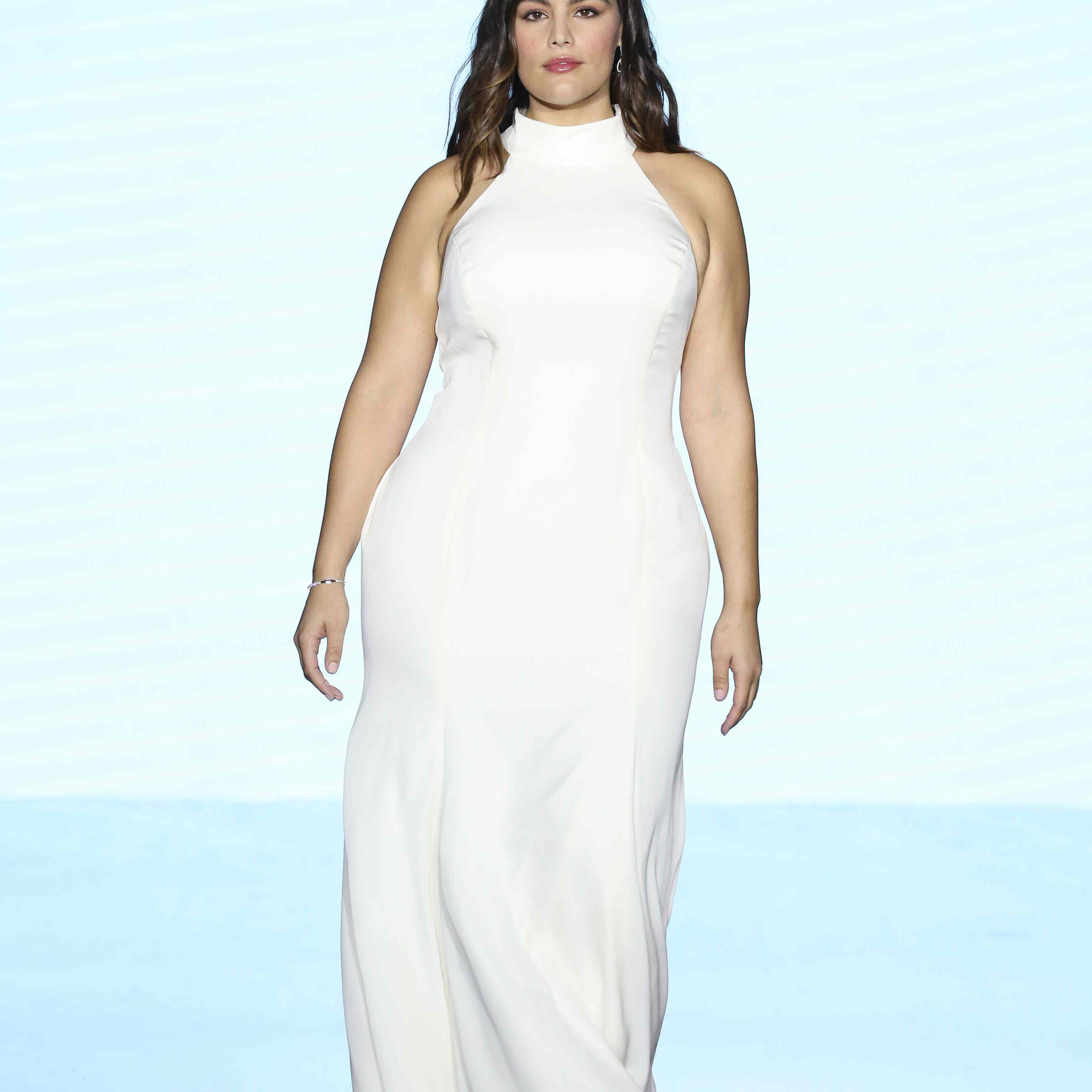 模特在t台上穿着合身的高领缎紧身礼服