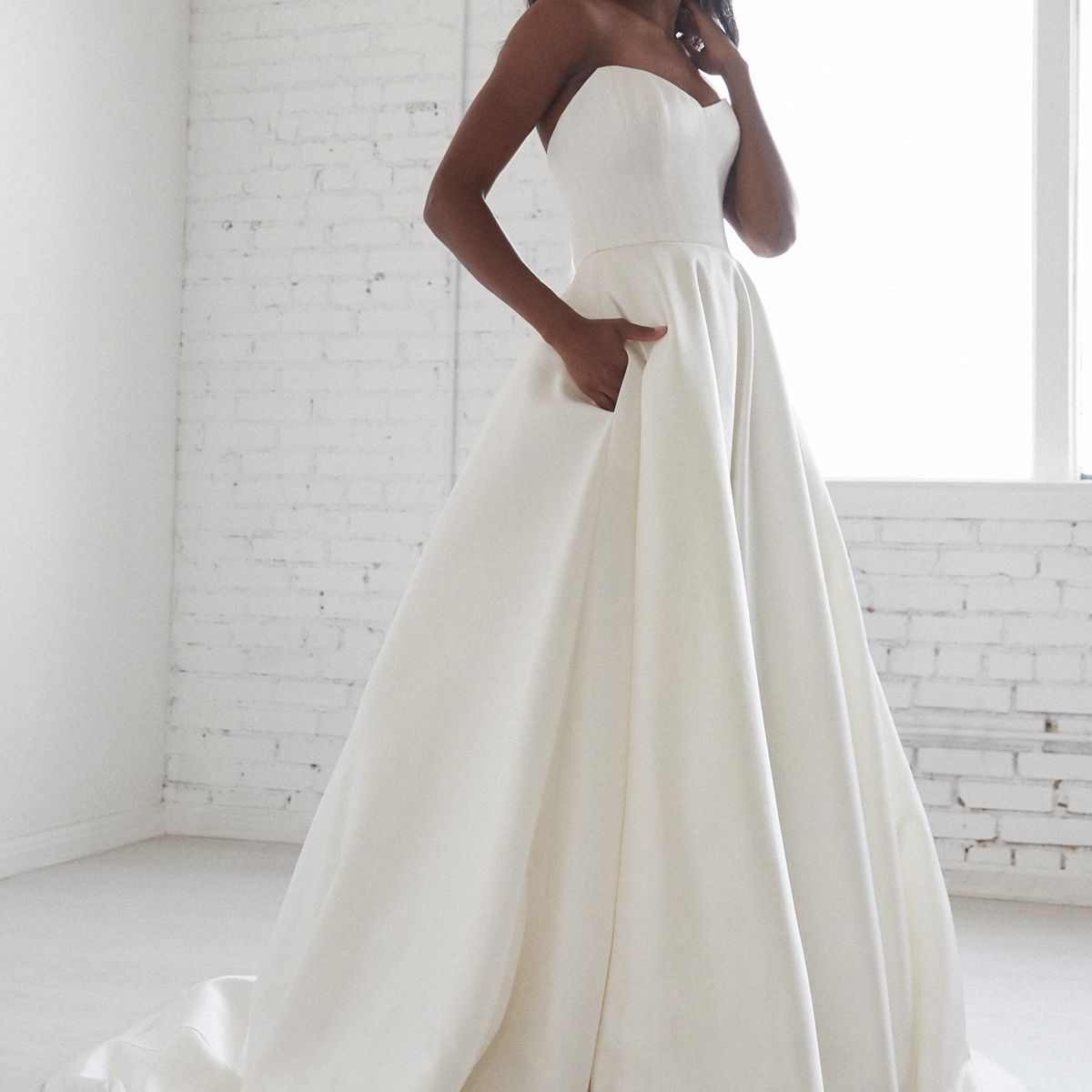 模特在无肩带缎舞会礼服裙口袋